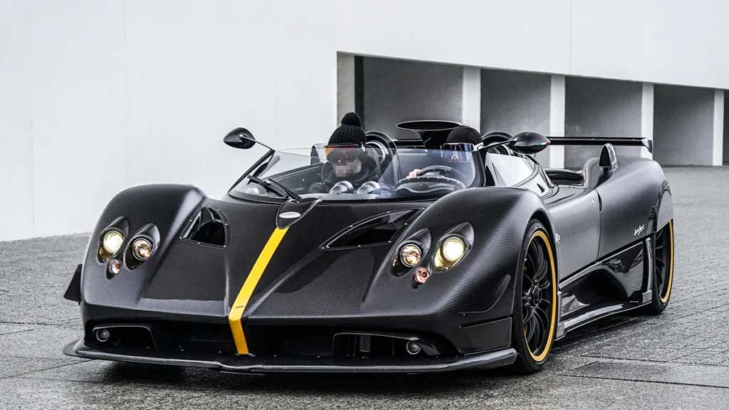 Pagani Zonda HP Barchetta blue hypercar with open-top design, carbon fiber body and Mercedes-AMG V12 engine on a scenic road.