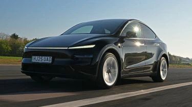 Tesla Model Y 2026 electric SUV parked on a road showcasing its modern design, long range, advanced technology and premium features.