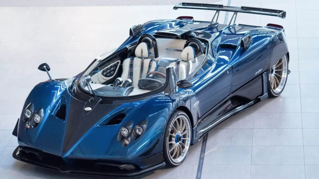 Pagani Zonda HP Barchetta blue hypercar with open-top design, carbon fiber body and Mercedes-AMG V12 engine on a scenic road.