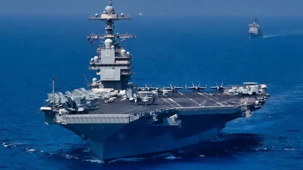 USS Gerald R. Ford (CVN-78), the world's most expensive nuclear-powered aircraft carrier sailing in the open sea with fighter jets on the flight deck.