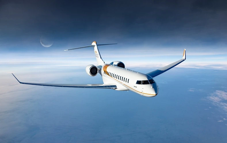 Bombardier Global 8000 flying above clouds at sunset
